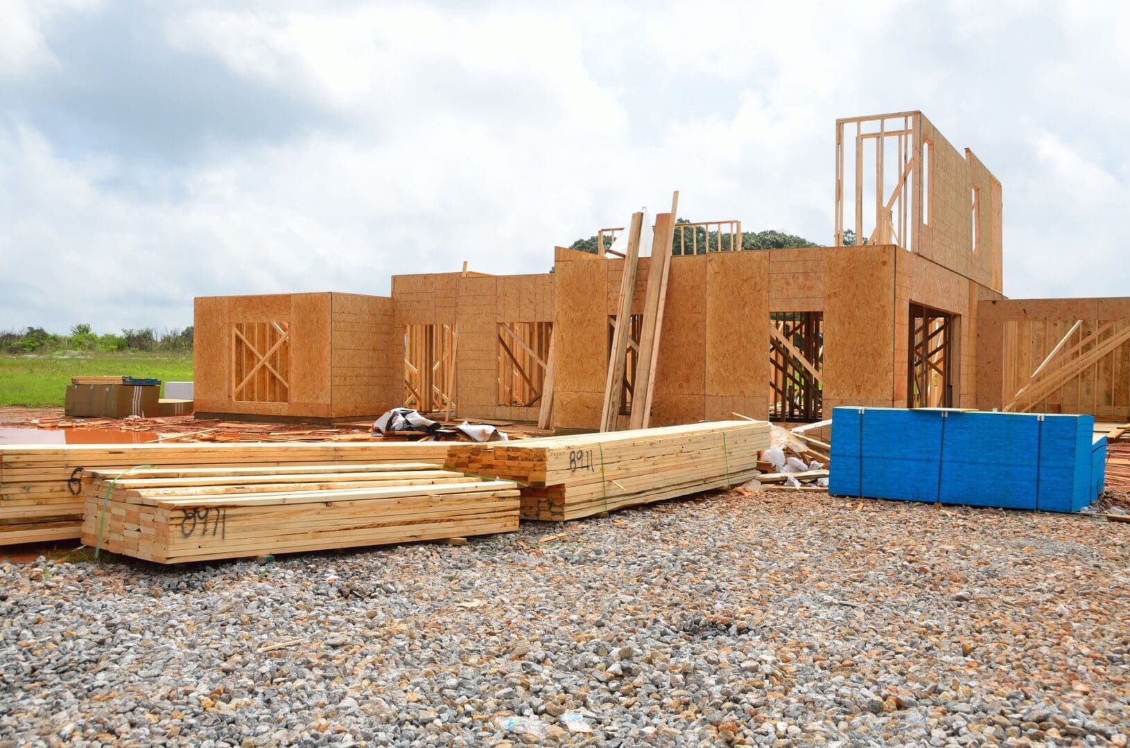 A building under construction with some wood and blue boxes.