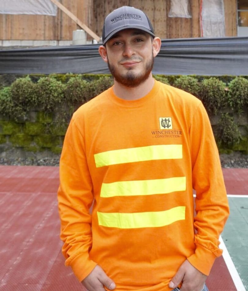 A man in an orange shirt and hat.