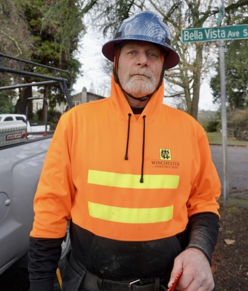 A man in an orange jacket and hard hat.